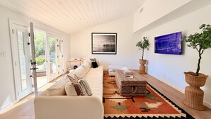 A modern living room with a sofa, a rug, and two potted plants. - Ojai Valley Luxury Hillside Estate (Ojai)