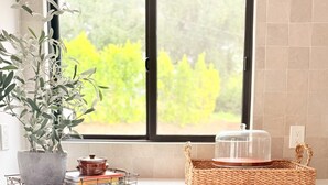A kitchen with a window, a potted plant, a basket, a tea set, and a Sharp oven. - Ojai Valley Luxury Hillside Estate (Ojai)