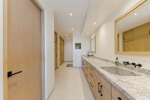 A modern bathroom with a large sink, mirror, and wooden cabinets. - Spacious 3-bedroom condo in charming San Jose del Cabo (San Jose del Cabo)