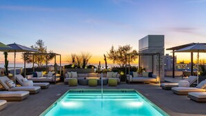 A rooftop pool area with lounge chairs, a pool, and a view of the sunset. - The Rose Quartz' Rooftop Pool, Luxury 2BR 2BA Santa Monica Beach, Walk To Pier (Santa Monica)