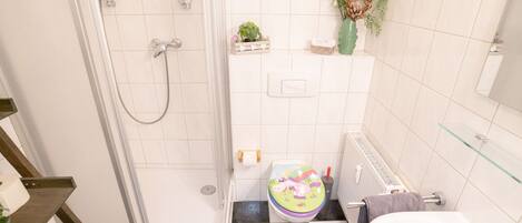 A bathroom with a shower, toilet, and a sink.