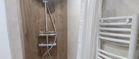 Chuveiro, secador de cabelo, toalhas de banho, papel higiênico
