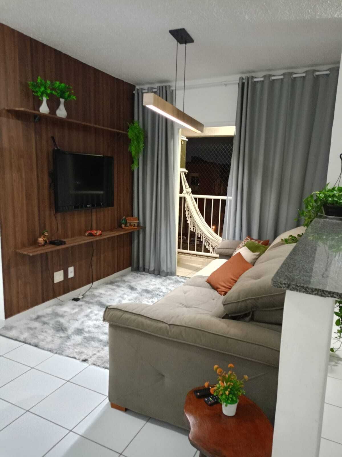 A modern living room with a sofa, TV, and a hammock.