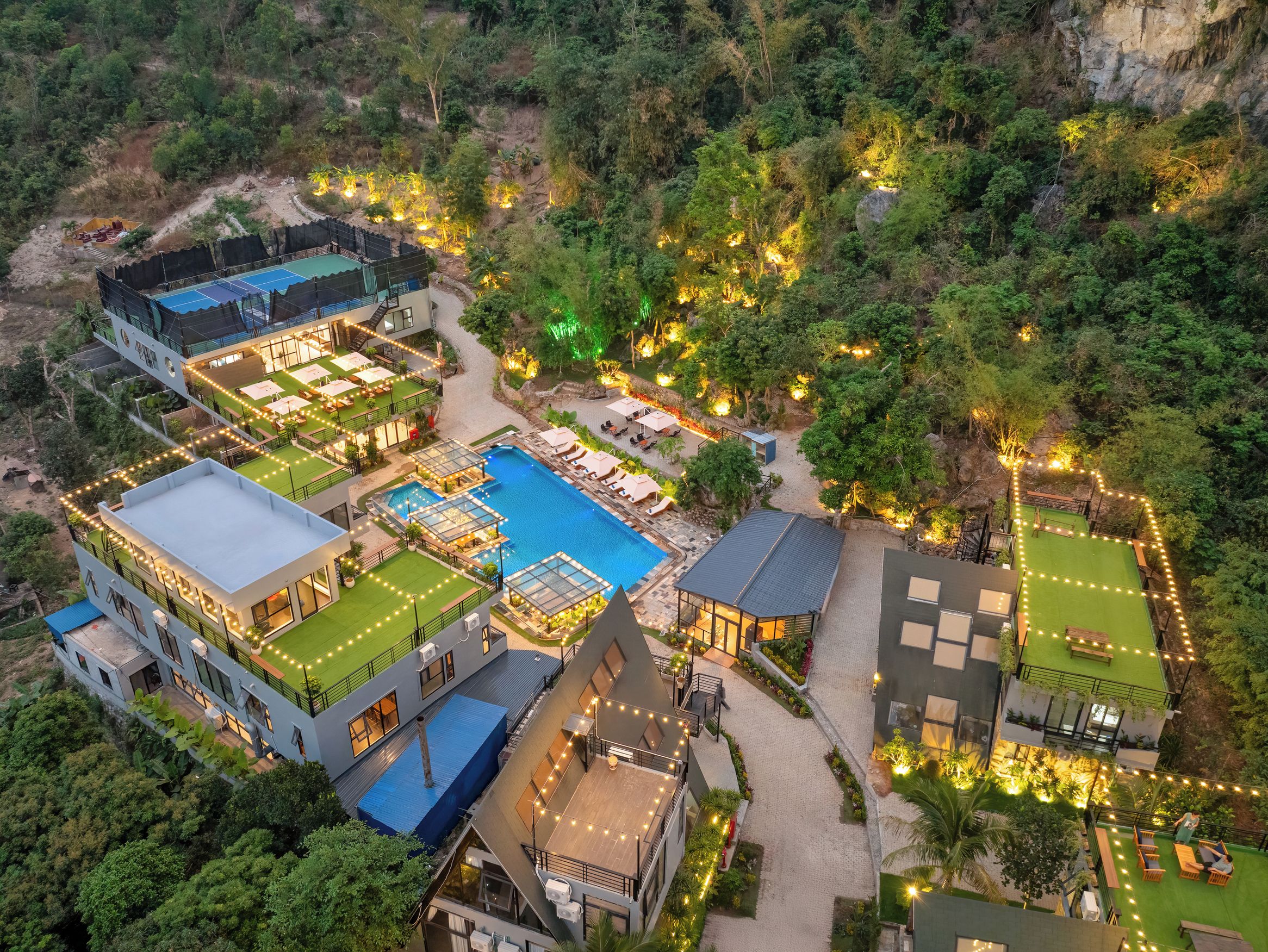 A resort with multiple buildings, a swimming pool, and outdoor seating areas.