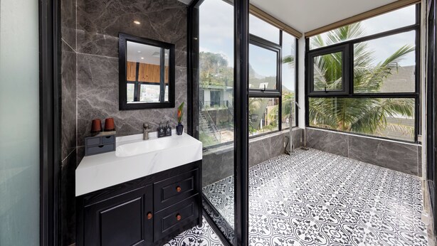 Une salle de bain avec une grande fenêtre, un lavabo et un miroir.