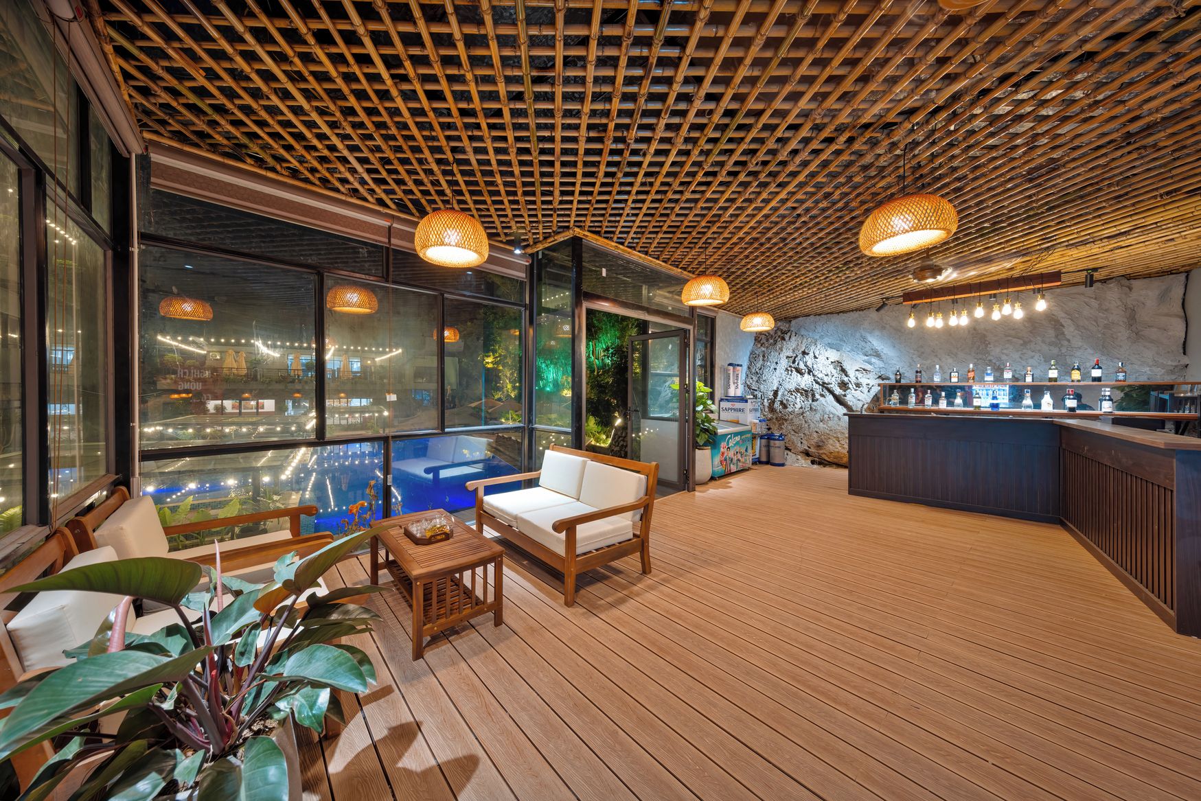 A modern bar area with a wooden floor, seating, and a bar counter with various bottles.