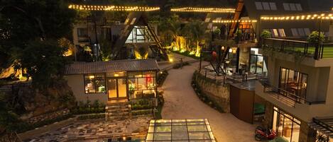 A resort with a swimming pool, outdoor seating, and a mountain backdrop.