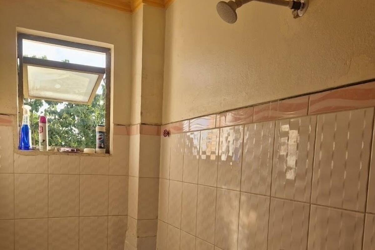 Un baño pequeño con inodoro, ventana y ducha.