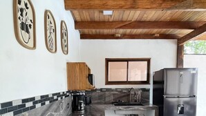 Une cuisine moderne avec un réfrigérateur noir, une cuisinière et une fenêtre.