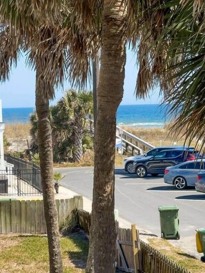 A residential area with a view of the beach, parked cars, and a wooden fence. - Vitamin Sea Condo (Jacksonville Beach)