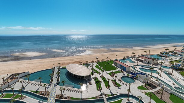 Ein Resort mit mehreren Swimmingpools, einem Strand und freiem Blick auf den Ozean.