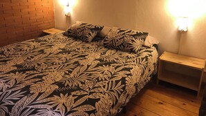 A room with a bed, two nightstands, and a brick wall. - CA LA ROSITA Charming house in Solsona, Ideal for families or couples. (Solsona)