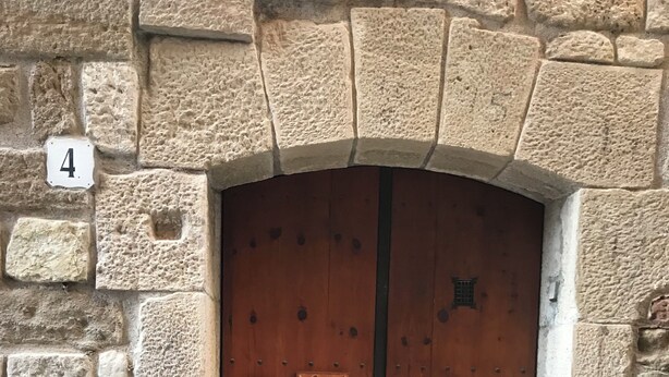 A wooden door with a plaque reading "Casa de la Rosa" and a number "4" above it, set in a stone wall. - CA LA ROSITA Charming house in Solsona, Ideal for families or couples. (Solsona)