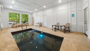Zona de piscina con vista a la vegetación, una banca y una puerta.