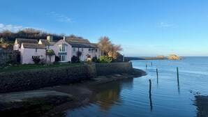A coastal house with a stone wall and a view of the sea. - Cornish coastal escape, close to the beach, shops, cafes and restaurants. (Bude)