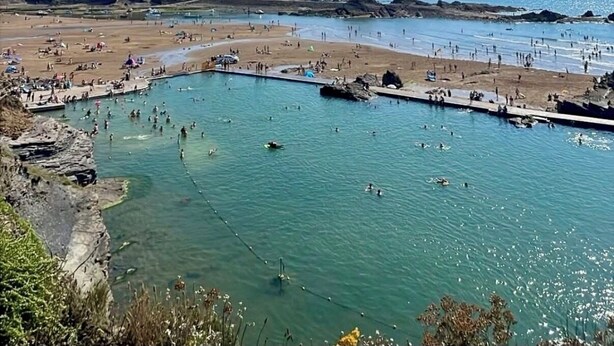 A coastal beach with clear water, rocky cliffs, and a sandy shore. - Cornish coastal escape, close to the beach, shops, cafes and restaurants. (Bude)