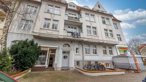 A historic building with multiple floors, a central entrance, and a bicycle parking area. - Spacious ground floor loft with 140 m² - ideal for families & groups of up to 6 (7) people (Magdeburg)