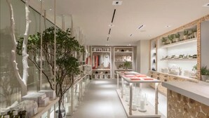 A modern retail store with glass display cases, a central walkway, and shelves with products. - Stunning Beach Condo with Balcony (Miami Beach)