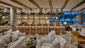 Un vaste espace de détente avec un bar, des sièges confortables et une vue sur l’extérieur.