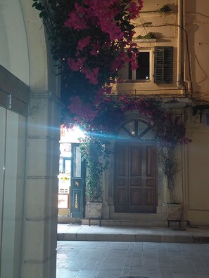 An arched doorway leading to a building with a wooden door and a potted plant. - Stay by Liston,Discover Corfùs old town (Kerkira)