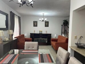 A living room with a fireplace, two sofas, a coffee table, and a chandelier. - Beautiful entire house near Alameda, Saltillo (Saltillo)
