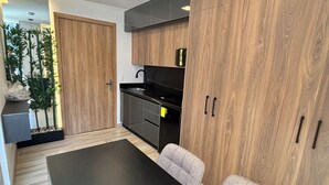 Eine moderne Küche mit Holzausstattung, einer schwarzen Arbeitsplatte und einem eingebauten Herd.