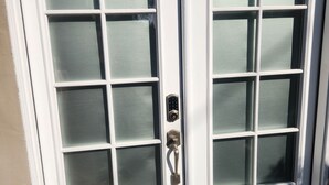 A white double door with a frosted glass pattern, a metal handle, and a small step leading up to it. - Updated Studio in LA with refreshing AC & Washer/Dryer (Los Angeles)