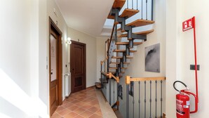 A hallway with a wooden staircase, a fire extinguisher, and a door labeled "3". - La Perla del Sangro (Castel di Sangro)