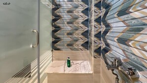 A bathroom with a glass shower door, a marble sink, and a patterned tile backsplash. - Spacious 4-bedroom apartment in awesome Giza Governorate with AC (Giza Governorate)