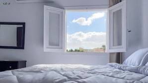 A bedroom with a bed, a window with open shutters, a mirror, and a dresser. - Spacious 4-bedroom apartment in awesome Giza Governorate with AC (Giza Governorate)