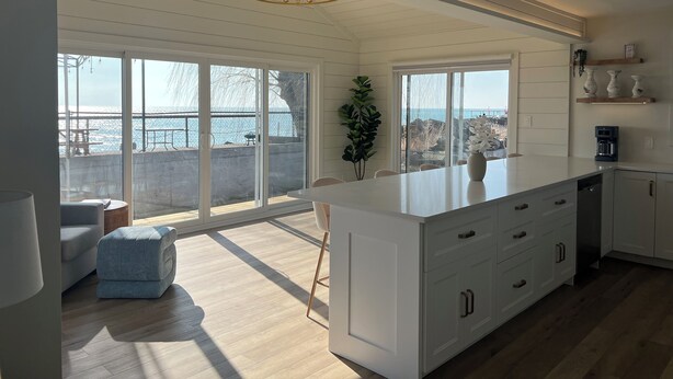 Una cocina moderna con amplios ventanales, una isla central y vistas al océano.