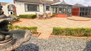 A patio area with a stone fountain, a gazebo, and a seating area with chairs and a table. - Superb Moorehouse Holiday Let private garden games room  & bar Pet freindly! (Thornton-Cleveleys)