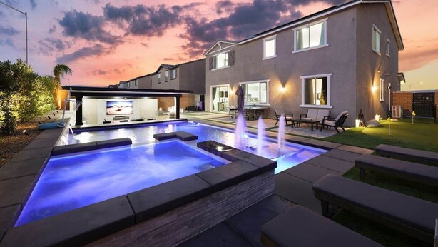 Una casa moderna con piscina, mobiliario exterior y un patio.