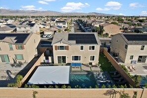 Un quartier résidentiel avec des maisons, une piscine et des panneaux solaires.