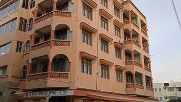 Un hotel de varios pisos con balcones y un letrero que indica que es un Apart-Hotel Global African.