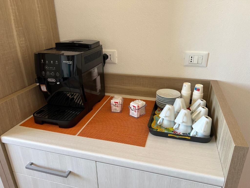 Eine Küchenzeile mit Kaffeemaschine, Mikrowelle und einer Servierplatte mit Tassen und Tellern.