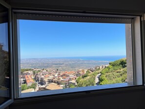 Vista desde una ventana sobre un pueblo con edificios y un cielo azul despejado.