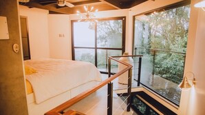 A bedroom with a bed, a window, and a staircase. - Loft by the Lagoon: Bathtub with View & Nature (Florianópolis)