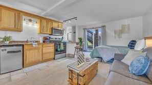 Un espace de vie compact comprenant une kitchenette, un coin repas et une chambre avec vue.