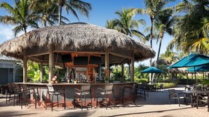 A thatched-roof bar area with outdoor seating and a sign reading "Paradise". - Cozy 2-bedroom condo with AC in charming Bonita Springs (Bonita Springs)
