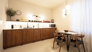 Una cocina moderna con armarios de madera, un microondas y un comedor con una mesa y sillas.