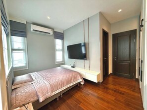 A bedroom with a bed, a TV mounted on the wall, an air conditioner, and a door. - Luxury House Near Suvarnabhumi Airport (Bang Phli)