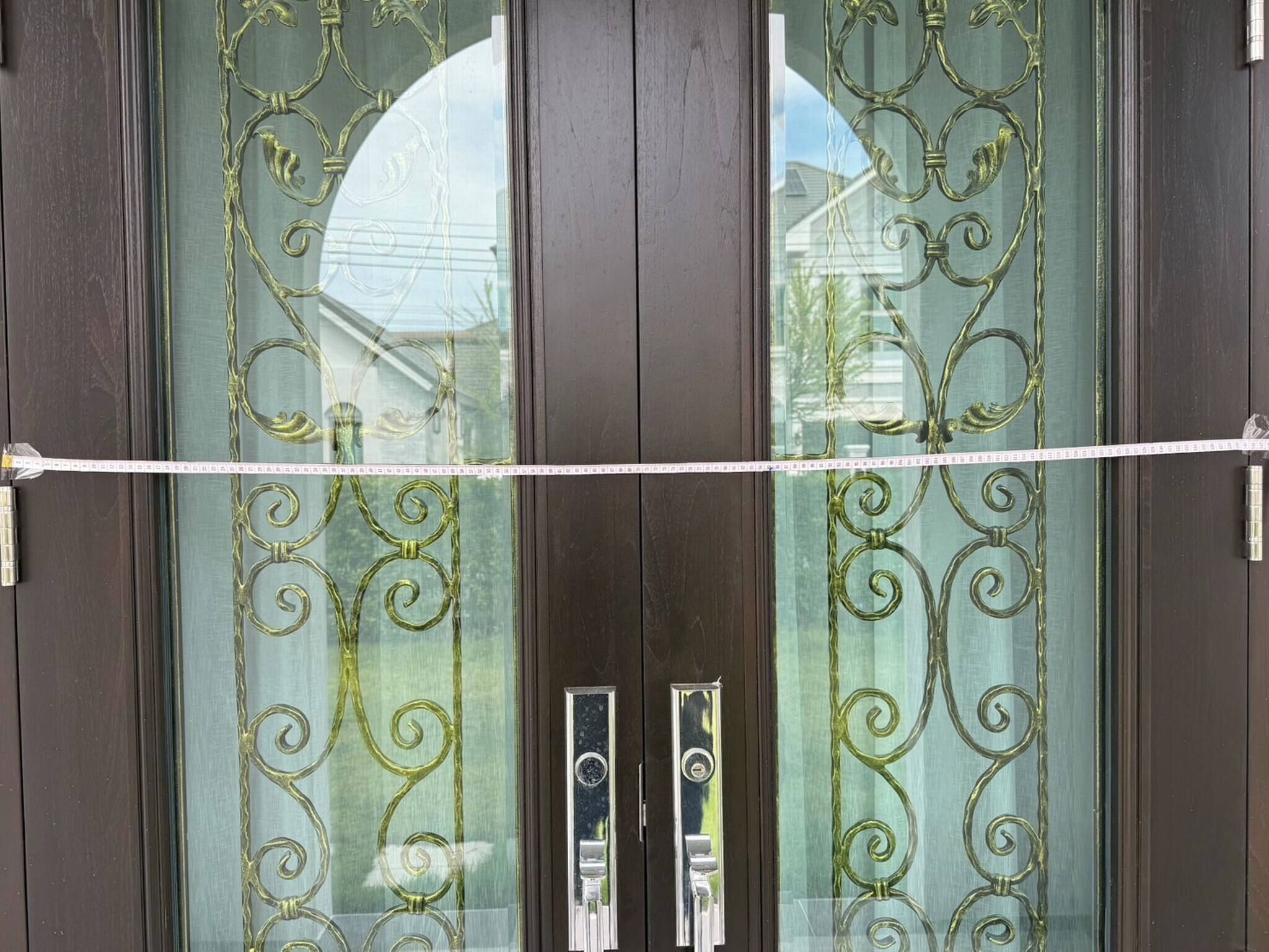 Eine Tür mit aufwändiger Metallverzierung und einem Maßband.