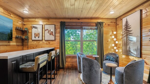 Ein Holzinterieur mit Barbereich, Sitzgelegenheiten und Kunstwerken.