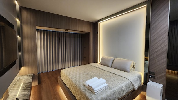 Une chambre d’hôtel moderne dotée d’un grand lit, d’une armoire intégrée et d’un téléviseur à écran plat.