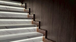 Un escalier avec des marches en marbre et des panneaux de bois.