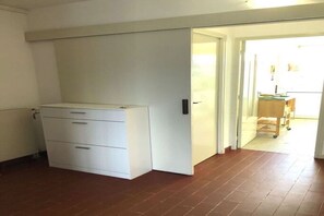 A room with a white cabinet, a tiled floor, and a door leading to another area. - Mountain and sea view apartment (Banyuls-sur-Mer)