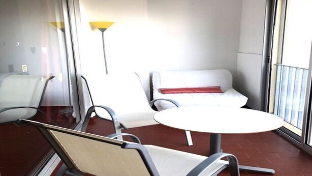 Ein Hotelzimmer mit Balkon, einem runden Tisch und zwei weißen Stühlen.