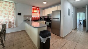 A modern kitchen with a central island, stainless steel appliances, and a tiled floor. - Golden Dream Villa 2nd floor A (Isabela)