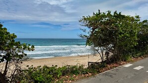 A beach with a road and greenery. - Golden Dream Villa 2nd floor A (Isabela)